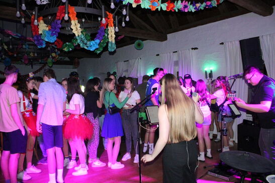 Volle Tanzfläche mit kostümierten Feiernden
