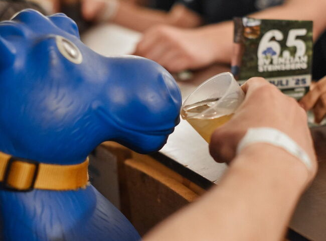 Einem blauen Hüpfpferd wird ein Getränk angeboten