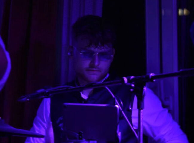 Dennis spielt mit cooler Sonnenbrille Schlagzeug