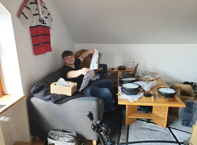 Bandmitglied beim Aufbau eines Schlagzeugs
