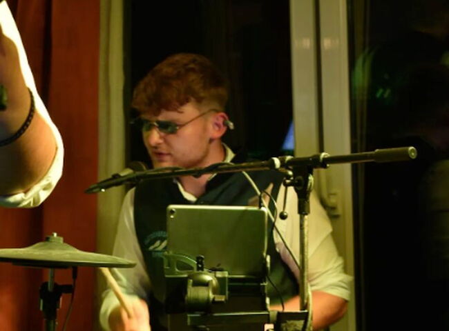 Dennis spielt mit cooler Sonnenbrille Schlagzeug