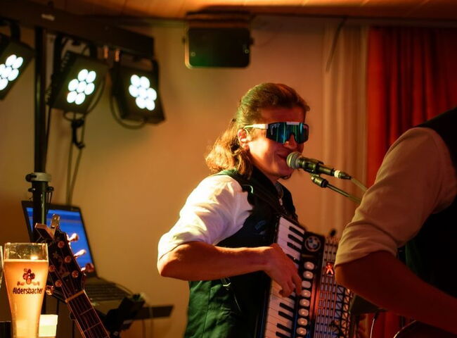 Thomas spielt auf dem Akkordeon und trägt eine coole Sonnenbrille