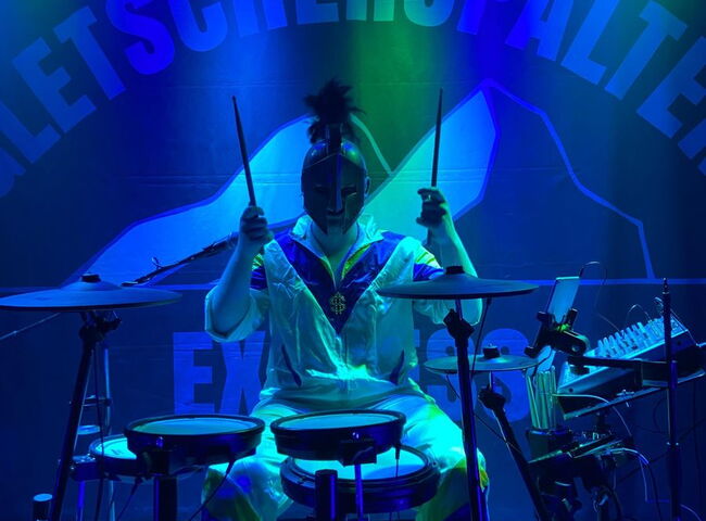 Dennis mit Römermaske hinter dem Schlagzeug